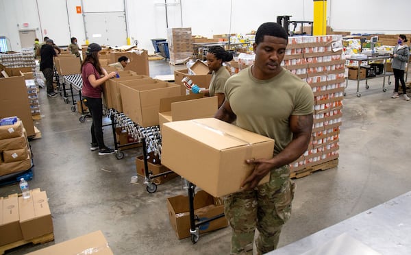 National Guard Pfc. Onyekachukwu Enenmuo weighs boxes of supplies at the Atlanta Community Food Bank headquarters Friday, May 22, 2020. STEVE SCHAEFER FOR THE ATLANTA JOURNAL-CONSTITUTION