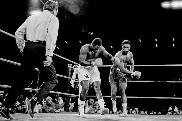 FILE - Joe Frazier is staggered by hard right in second round of heavyweight title fight by challenger George Foreman in Kingston, Jamaica, on Jan. 23, 1973. (AP Photo, File)