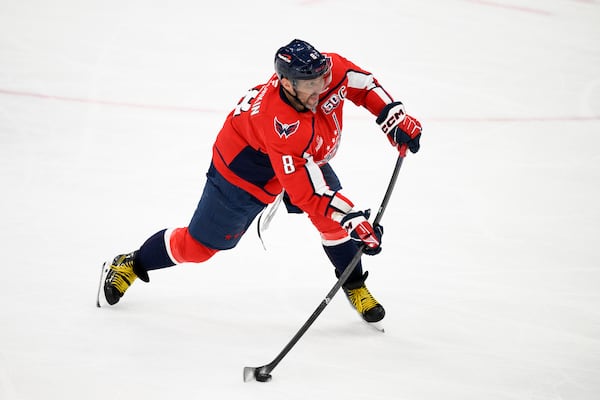 Washington Capitals left wing Alex Ovechkin (8) shoots the puck for an empty net goal and a hat trick during the third period of an NHL hockey game against the Edmonton Oilers, Sunday, Feb. 23, 2025, in Washington. (AP Photo/Nick Wass)