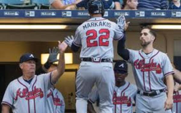 Nick Markakis is congratulated by Brian Snitker (left) and Ender Inciarte after Markakis homered in the second inning of Monday's Braves win at Milwaukee. (AP photo)