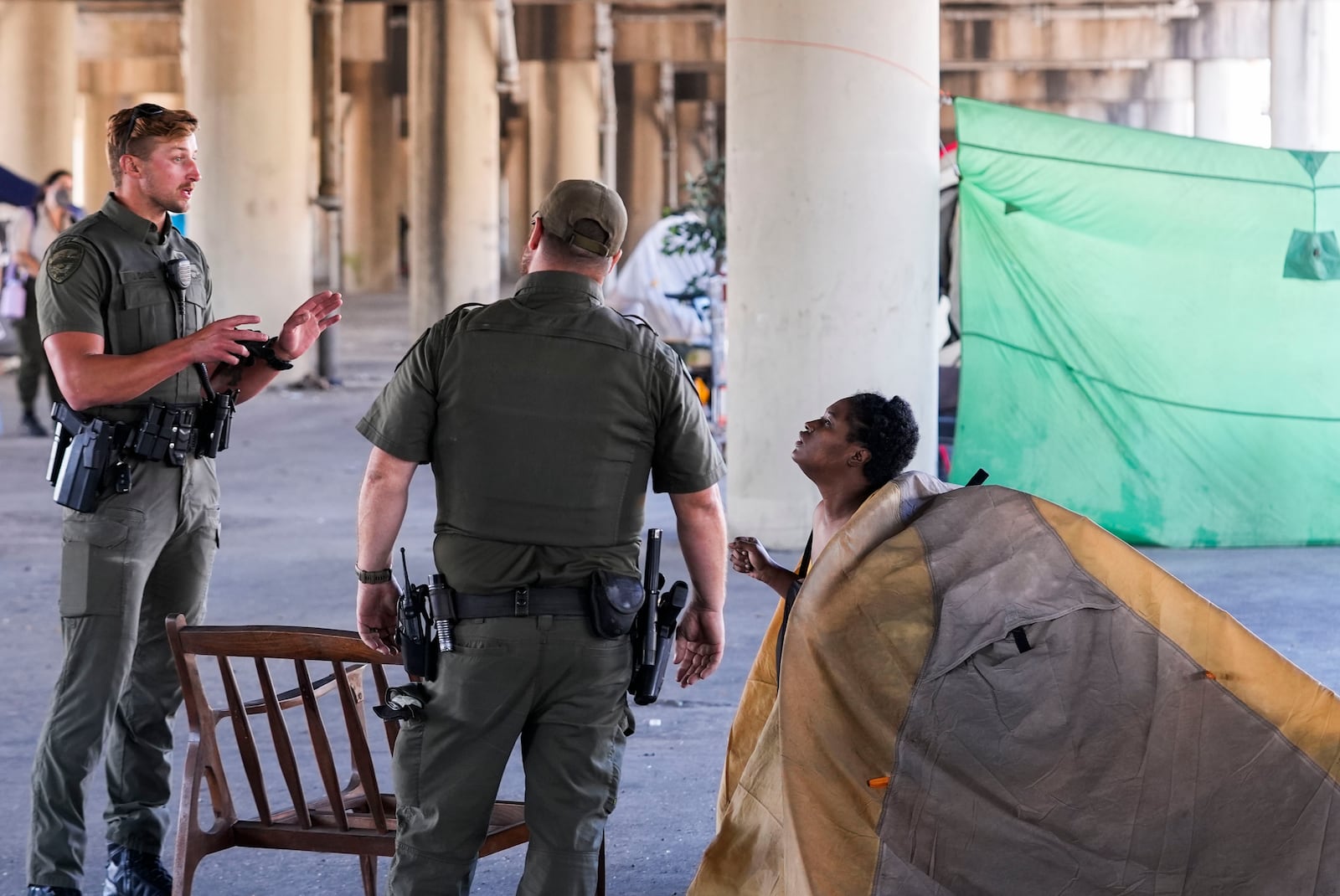 Louisiana Wildlife and Fisheries agents assist state police as they give instructions to people living in a homeless encampment to move to a different pre-designated location as they perform a sweep in advance of a Taylor Swift concert in New Orleans, Wednesday, Oct. 23, 2024. (AP Photo/Gerald Herbert)