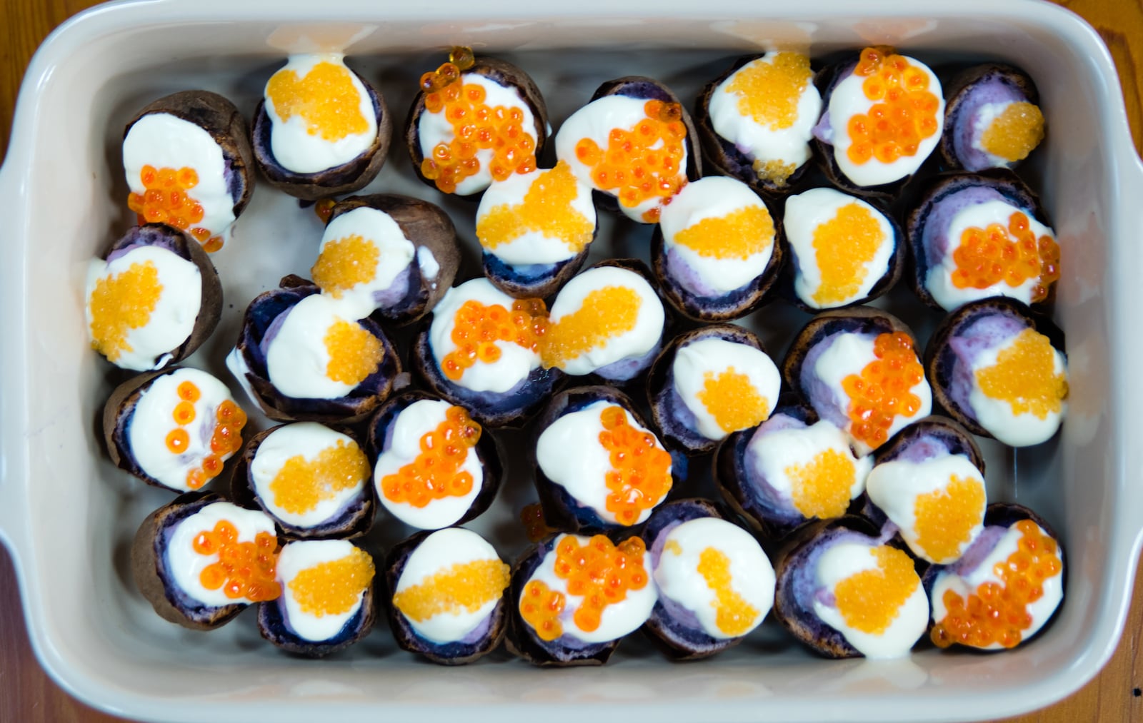 This appetizer of baked purple fingerling potatoes with creme fraiche and salmon roe is from 2017. Henri Hollis/henri.hollis@ajc.com