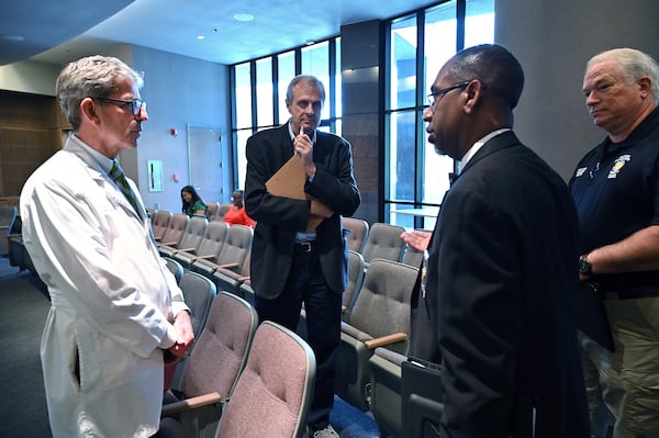 From left, Steven Kitchen, chief medical officer at Phoebe Putney Memorial Hospital, Charles Ruis, district health director at DPH, Dougherty County Coroner Michael Fowler, and Dougherty County EMS Director Sam Allen confer after a press conference to  provide a Coronavirus update at Albany Government Center in Albany on Tuesday, March 24, 2020. Well off the interstate some 180 miles south-southwest of Atlanta, Albany's struggles with the Coronavirus stick out like a sore thumb on the state's map, as small towns in the region like Americus and Sylvester reported their first cases of the virus on Friday. (Hyosub Shin / Hyosub.Shin@ajc.com)