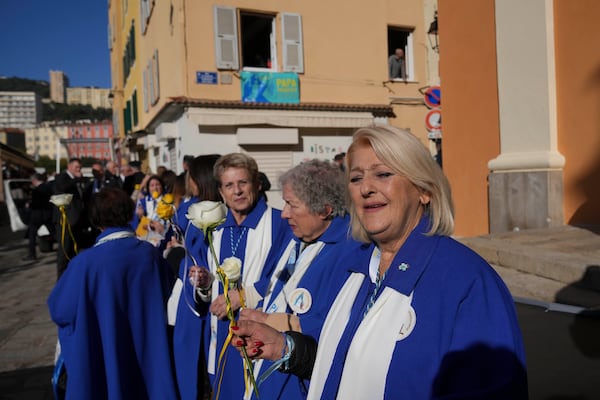 Faithful wait for the arrival of Pope Francis outside the Cathedral of Our Lady of the Assumption of Ajaccio on the occasion of his one-day visit in the French island of Corsica, Sunday, Dec. 15, 2024. (AP Photo/Alessandra Tarantino)