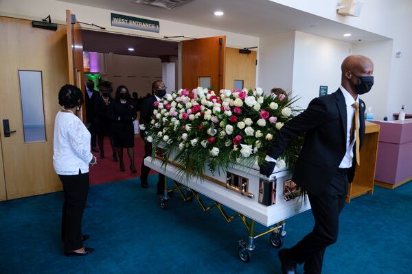 Funeral service staff wheel the casket of Gwinnett County Tax Commissioner Tiffany Porter at her funeral in Atlanta on Thursday, May 12, 2022. Porter, who died of cancer at 43, was the first Black tax commissioner in Gwinnett and previously the first Black judge in Duluth. (Arvin Temkar / arvin.temkar@ajc.com)