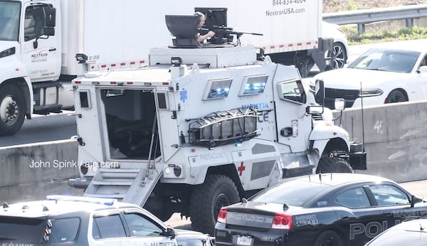 A sniper sits atop a Marietta SWAT vehicle during a standoff with an armed driver on the side of I-75 South in Cobb County. 