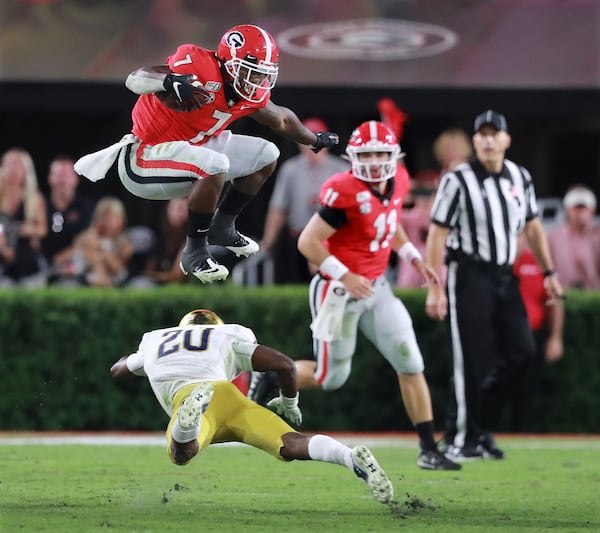 Georgia tailback D'Andre Swift leaps over Notre Dame cornerback Shaun Crawford.  Curtis Compton/ccompton@ajc.com