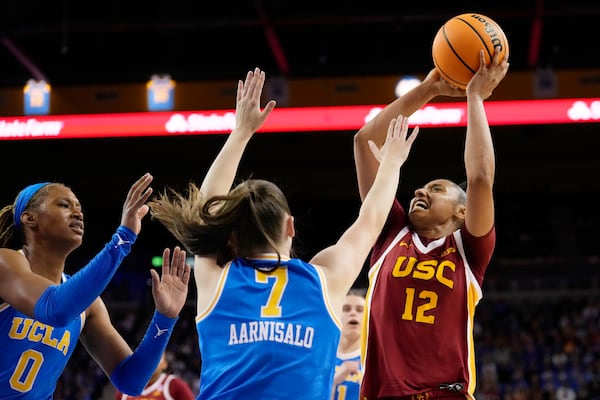 Southern California guard JuJu Watkins, right, shoots as UCLA forward Janiah Barker, left, and guard Elina Aarnisalo defend during the second half of an NCAA college basketball game Saturday, March 1, 2025, in Los Angeles. (AP Photo/Mark J. Terrill)