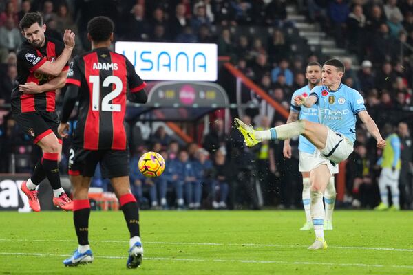 Manchester City's Phil Foden, right, attempts a shot on goal during the English Premier League soccer match between Bournemouth and Manchester City at the Vitality stadium in Bournemouth, England, Saturday, Nov. 2, 2024. (AP Photo/Kirsty Wigglesworth)