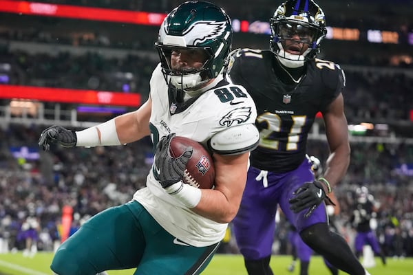 Philadelphia Eagles tight end Dallas Goedert (88) scores a touchdown in front of Baltimore Ravens cornerback Brandon Stephens (21) during the first half of an NFL football game, Sunday, Dec. 1, 2024, in Baltimore. (AP Photo/Stephanie Scarbrough)