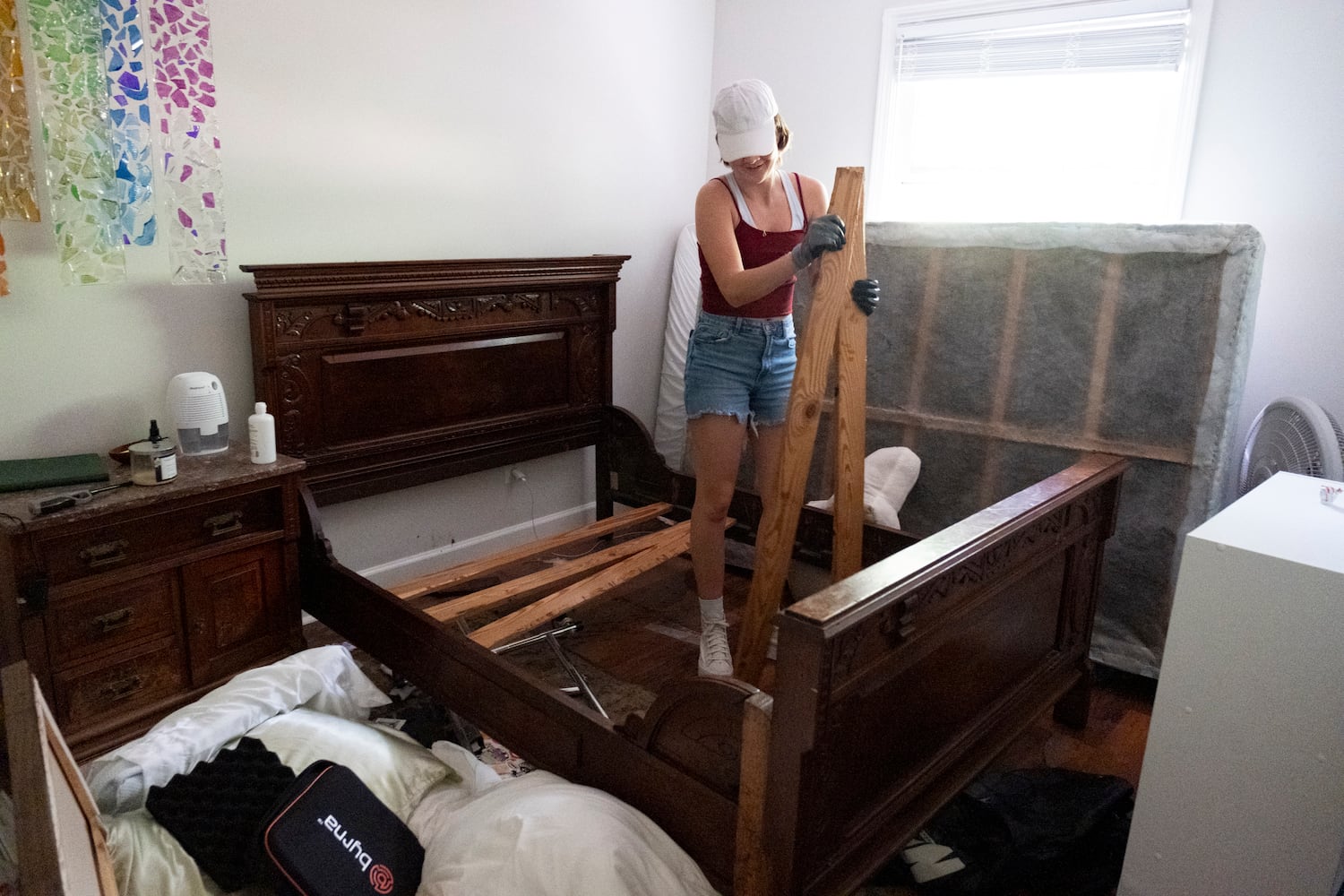 Hope Ferguson disassembles her bed while cleaning up her flooded apartment at the Peachtree Park Apartments in Atlanta on Saturday, Sept. 28, 2024.   Ben Gray for the Atlanta Journal-Constitution