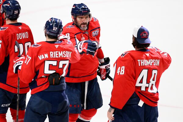 Washington Capitals left wing Alex Ovechkin (8) celebrates with defenseman Trevor van Riemsdyk (57) and goaltender Logan Thompson (48) after an NHL hockey game against the Philadelphia Flyers, Thursday, March 20, 2025, in Washington. (AP Photo/Nick Wass)