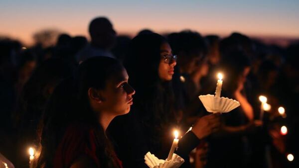 Students and family members hold candles during a vigil for victims of the mass shooting at Marjory Stoneman Douglas High School in Parkland, Florida.