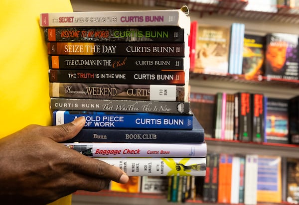 Curtis Bunn holds the books he authored at Medu Bookstore at Greenbriar Mall on July 11, 2023 in Atlanta. Bunn, founder of The National Book Club Conference is preparing his annual conference. (Michael Blackshire/Michael.blackshire@ajc.com)