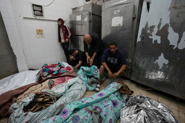 Palestinians mourn over relatives killed in an Israeli bombardment in Nuseirat, central Gaza, as they stand in a hospital morgue in Deir al-Balah, Gaza Strip, Wednesday, Nov. 20, 2024. (AP Photo/Abdel Kareem Hana)