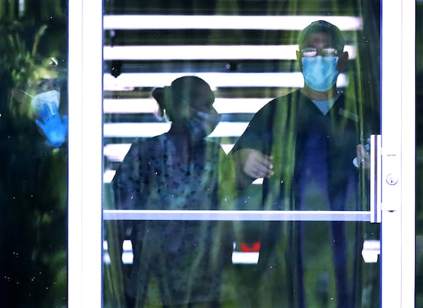 Carrollton Manor Inc., nursing home employees are seen working in a hallway at the facility. Trace Thompson, Carrollton Manor’s administrator, said getting adequate supplies was initially a problem, but that by the time the facility had its first resident test positive at the end of March, it did have masks and other PPE. (Curtis Compton / ccompton@ajc.com)