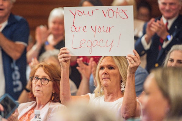 An audience member holds a sign during a State Election Board meeting in Atlanta on Tuesday, July 9, 2024.  (Ziyu Julian Zhu / AJC)