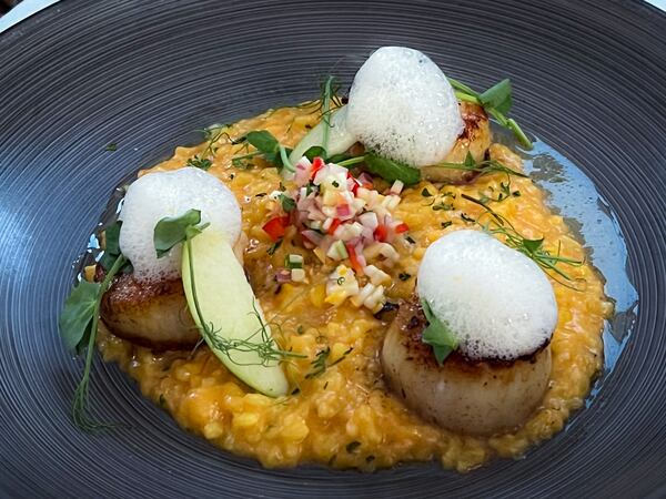 The scallops at Pêche were perfectly cooked, but the saffron risotto at its base desperately needed salt. Henri Hollis/henri.hollis@ajc.com