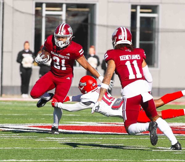 Massachusetts' Jalen John powers the ball up the field as he breaks through a tackle from Liberty's Bentley Henshaw during the first quarter of an NCAA football game in Hadley, Mass., Saturday, Nov. 16, 2024. ( J. Anthony Roberts/The Republican via AP)