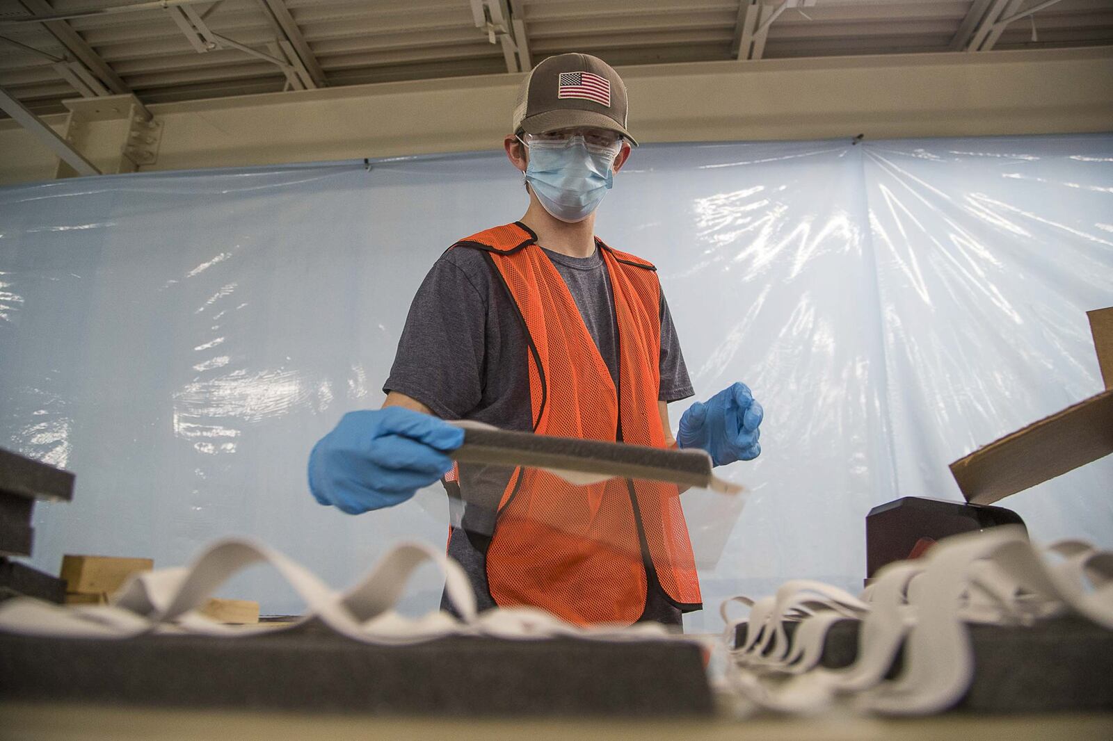 Dawson Coate prepares makeshift face shields for distribution to health-care workers at Mohawk Industries, Inc. in Calhoun on April 8, 2020. Mohawk, a giant in the flooring and carpet industry, has two facilities in North Georgia creating personal protective equipment for health-care workers in response to the COVID19 pandemic. (ALYSSA POINTER / ALYSSA.POINTER@AJC.COM)