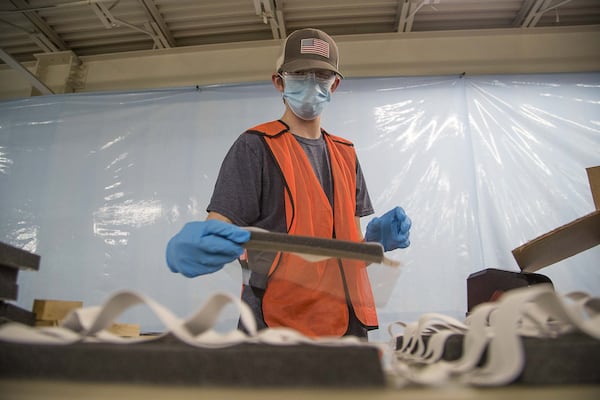 Dawson Coate prepares makeshift face shields for distribution to health-care workers at Mohawk Industries, Inc. in Calhoun on April 8, 2020. Mohawk, a giant in the flooring and carpet industry, has two facilities in North Georgia creating personal protective equipment for health-care workers in response to the COVID19 pandemic. (ALYSSA POINTER / ALYSSA.POINTER@AJC.COM)