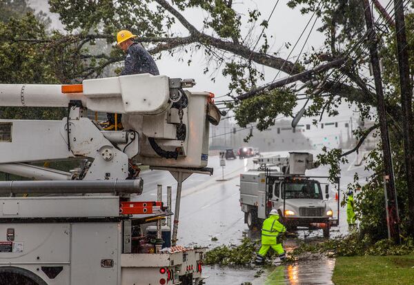 Crews work to clear a tree that fell on power lines on Hammond Drive, Monday, Sept. 11, 2017, in Sandy Springs, Ga.  BRANDEN CAMP/SPECIAL