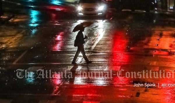 Steady rain was falling in downtown Atlanta on Tuesday morning, where a city dweller crossed Peachtree Street to Woodruff Park under the cover of an umbrella.