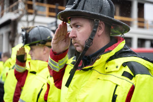 Firefighters salute as a funeral procession for fallen police officer Jeremy Labonte drives through downtown Roswell on Wednesday, February 12, 2025. The 24-year-old Roswell Police Department officer was shot to death on Friday evening. (Arvin Temkar / AJC)