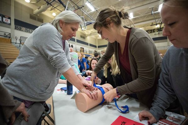 Nickajack elementary teachers Joan Lunsfurd, left, Callie Quinn, center, practice using a tourniquet as April Mitchell watches during an active shooter training seminar at Marietta High School, Monday, Feb. 26, 2018, in Marietta, Ga. BRANDEN CAMP/SPECIAL