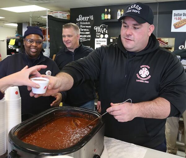 The Akron Fire Department won the People's Choice and Judge's Award at the 11th Annual Akron Firefighters Chili Challenge at Lock 3 Park on January 20, 2017, in Akron, Ohio. From left are Lt. Sierjie Lash, Capt. Scott Pascu, and Firefighter Adam Lovell. (Phil Masturzo/Akron Beacon Journal/TNS)