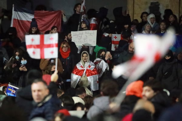 Demonstrators stand during a rally outside the parliament's building to protest the government's decision to suspend negotiations on joining the European Union for four years in Tbilisi, Georgia, on Saturday, Nov. 30, 2024. (AP Photo/Zurab Tsertsvadze)