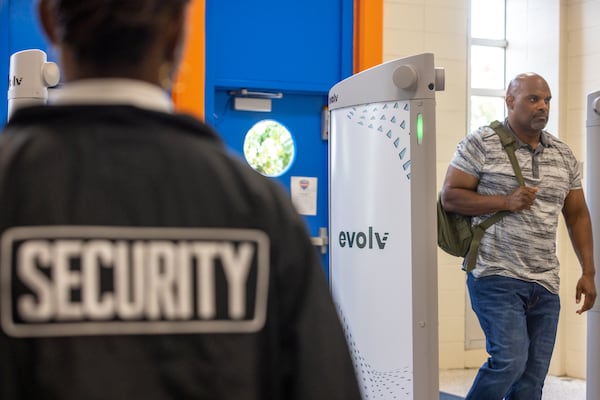 A plain clothes officer walks through the new Evolv Weapons Detection System during a demonstration at Columbia High School in Decatur on Thursday, Aug. 3, 2023. (Arvin Temkar/AJC)