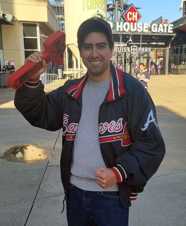 Andrew Swayne, a 32-year-old bartender from White Plains, New York, waves the Braves tomahawk that he has had since his first Braves game 20 years ago. (Sam Sinclair / Fresh Take Georgia)