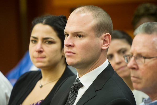 James Burns is flanked by his father, Richard Burns, and his wife, Lindsey Burns, during a preliminary hearing on August 1, 2016, in Atlanta. Burns is the former Atlanta police officer accused of murder in the shooting death of Deravis Caine Rogers. 