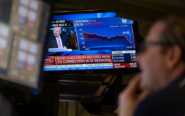 Stocks reflect declines on monitors Thursday as traders work on the floor of the New York Stock Exchange.