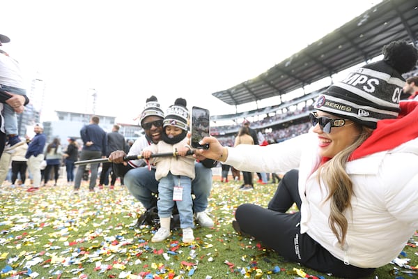 Liliana Armas takes a photo of Braves outfielder Guillermo Heredia and his daughter Leah Heredia. They are holding the spade that Heredia used at the stage to show the 'CHOP' his signature move that the Braves players adopted during the season on Friday, November 5, 2021.
Miguel Martinez for The Atlanta Journal-Constitution 