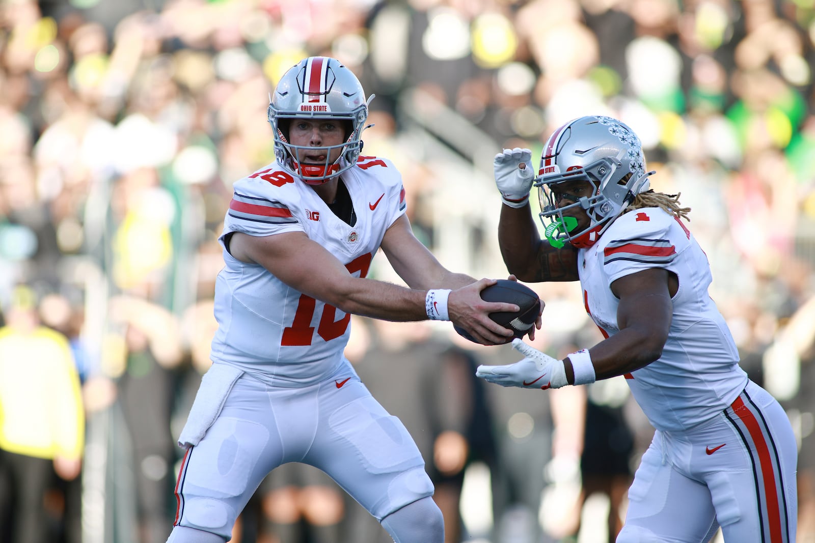 Ohio State quarterback Will Howard (18) hands off the ball to running back Quinshon Judkins, right, during an NCAA college football game against Oregon, Saturday, Oct. 12, 2024, in Eugene, Ore. (AP Photo/Lydia Ely)