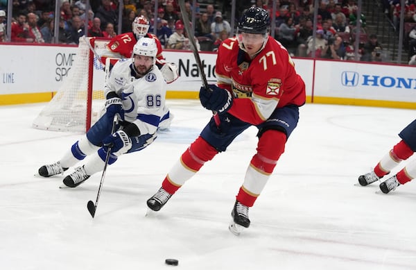 Tampa Bay Lightning right wing Nikita Kucherov (86) and Florida Panthers defenseman Niko Mikkola (77) go for the puck during the first period of an NHL hockey game Monday, March 3, 2025, in Sunrise, Fla. (AP Photo/Lynne Sladky)