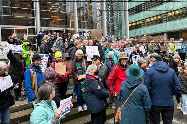 People gather outside the U.S. District Court after a federal judge blocked President Donald Trump's effort to halt the nation's refugee admissions system Tuesday, Feb. 25, 2025, in Seattle. (AP Photo/Eugene Johnson)