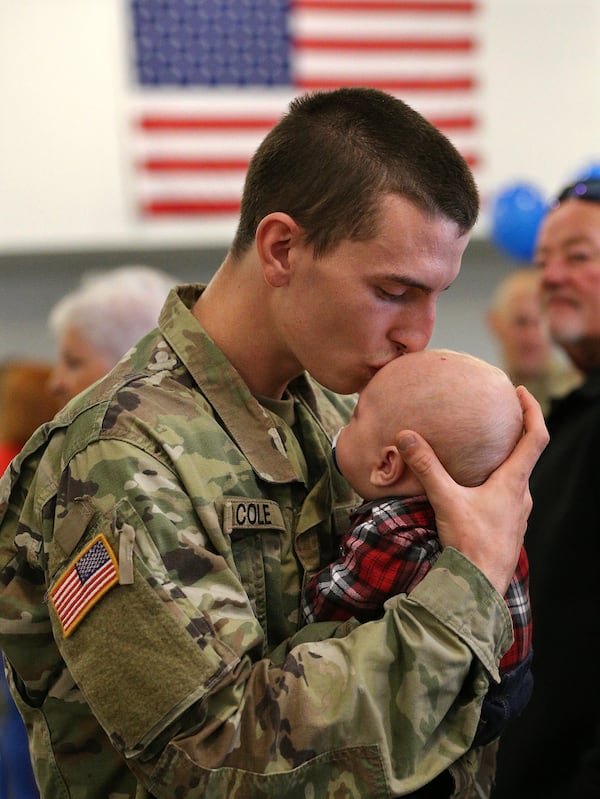 Spc. Devin Cole, a Georgia National Guardsman, gives his 2-month-old son, Dylan, a kiss goodbye before he boards a bus at the armory in Dalton. His unit is heading to Afghanistan for nine months. Curtis Compton/ccompton@ajc.com