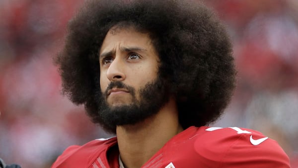 In this Dec. 11, 2016, file photo, San Francisco 49ers quarterback Colin Kaepernick stands in the bench area during the second half of the team's NFL football game against the New York Jets in Santa Clara, Calif. Kaepernick told CBS hell stand during the national anthem if given chance to play football in NFL again.