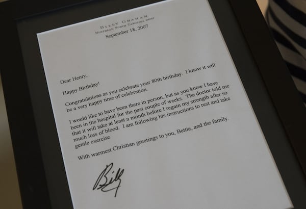 A signed letter from Billy Graham wishing the Rev. Henry Holley a happy 80th birthday is displayed at the Holley residence in Marietta. ALYSSA POINTER / ALYSSA.POINTER@AJC.COM