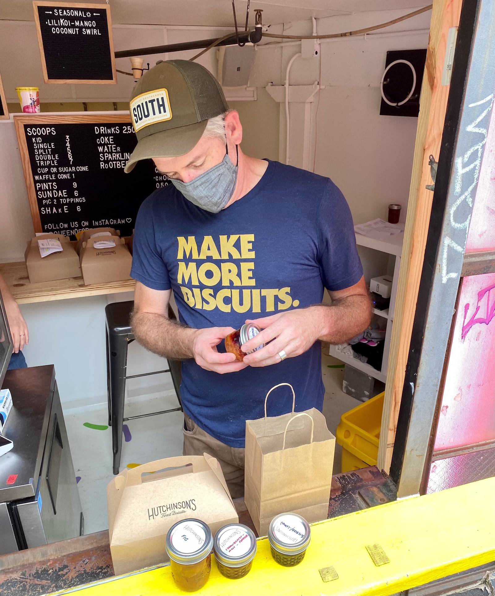 Todd Tharp, owner of Hutchinson’s Finest Biscuits, shows off his peach-blueberry jam at the pickup window of the Inman Park kitchen where he bakes every Sunday. Wendell Brock for The Atlanta Journal-Constitution