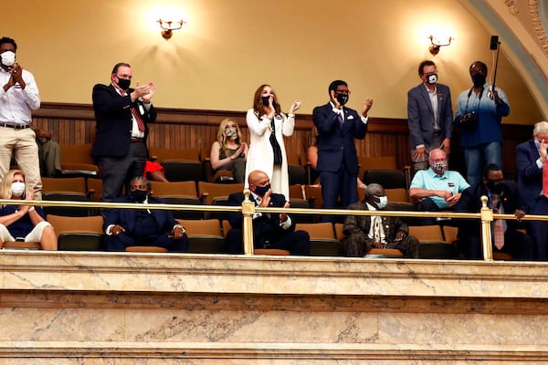 Observers in the House gallery applaud after the lawmakers voted by two-thirds to consider the suspension of the rules and introduce a bill to take down the state flag, Saturday, June 27, 2020 at the Capitol in Jackson, Miss. The resolution now heads to the Senate, where it will also take a two-thirds vote to pass. The current flag has in the canton portion of the banner the design of the Civil War-era Confederate battle flag, that has been the center of a long-simmering debate about its removal or replacement. (AP Photo/Rogelio V. Solis)