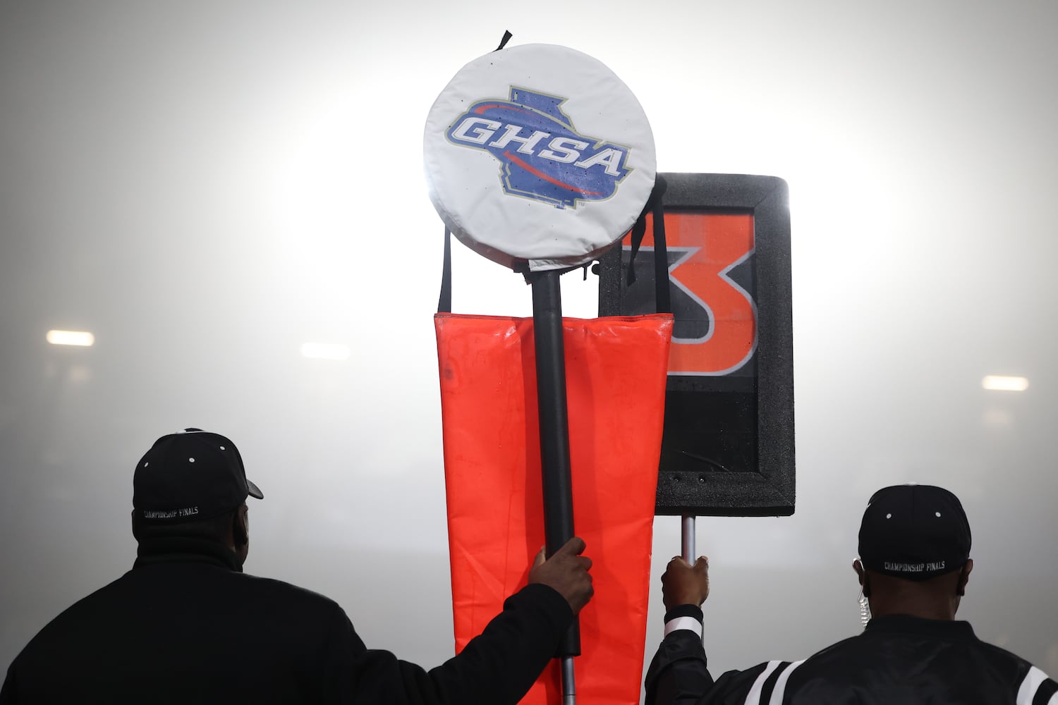 Fog fills the sky as officials hold GHSA markers on the sideline during the first half of the game between Buford and Langston Hughes in the Class 6A state title football game at Georgia State Center Parc Stadium Friday, December 10, 2021, Atlanta. JASON GETZ FOR THE ATLANTA JOURNAL-CONSTITUTION