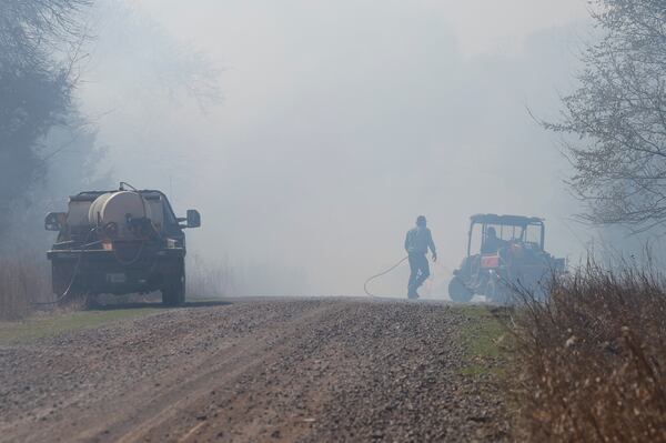 Fire crews and volunteers battle hot spots and new fires about 8 miles west of Stillwater, Okla., on Monday, March 17, 2025. (AP Photo/Alonzo Adams)