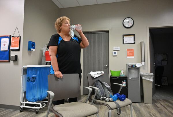 Stephanie Schroeder takes a water break during her pulmonary therapy session at Piedmont Henry Hospital's cardiac rehabilitation center in Stockbridge on Tuesday, August 10, 2021. Stephanie Schroeder, 50, is a COVID long-hauler who remains under the care of 11 doctors months after contracting the virus. (Hyosub Shin / Hyosub.Shin@ajc.com)