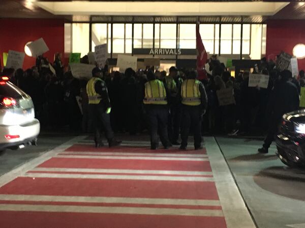 Jan. 29, 2017 - About a dozen police officers lined up outside Hartsfiled-Jackson Atlanta International Airport between the remaining protesters and the street on Sunday night. RHONDA COOK / RCOOK@AJC.COM