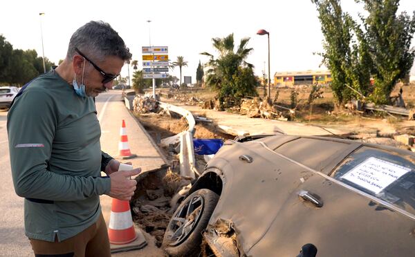 Jorge Tarazona stands next to a car in Paiporta, Valencia, Spain, Wednesday, Nov. 5, 2024, where his three-year-old niece and sister-in-law died in last week's floods in eastern Spain. (AP Photo/Paolo Santalucia)