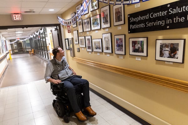 Dr. Woody Morgan, attending physician in Shepherd Center’s Comprehensive Rehabilitation Unit, looks at pictures of former military patients at Shepherd Center in Atlanta. Bernie Marcus has donated to the center. Arvin Temkar/AJC file